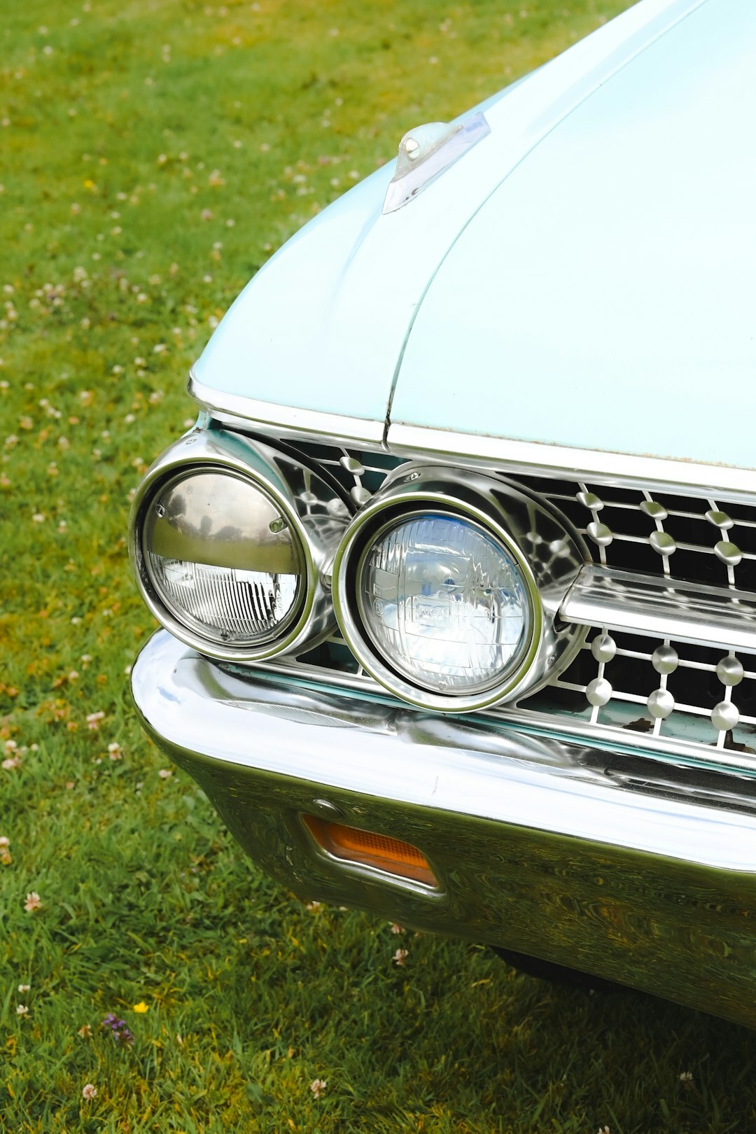 Close-up of a vintage automobile chrome grille and headlight detail