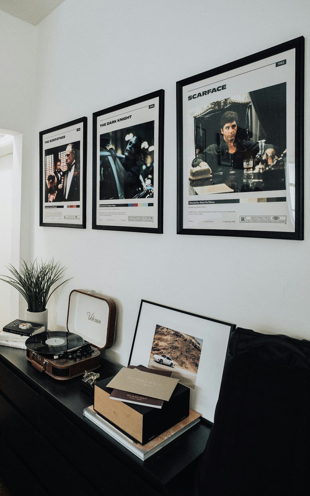 Editor examining archival photographs of classic automobiles at a desk