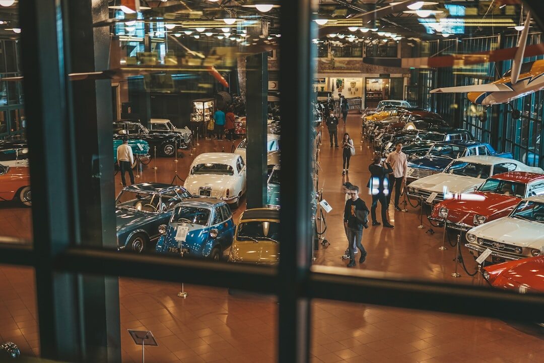 Visitors admiring a row of classic automobiles at an exhibition